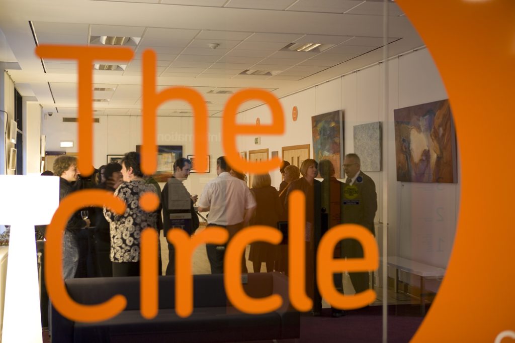 Circle logo displayed in the window of an office building, reflecting a modern corporate identity.