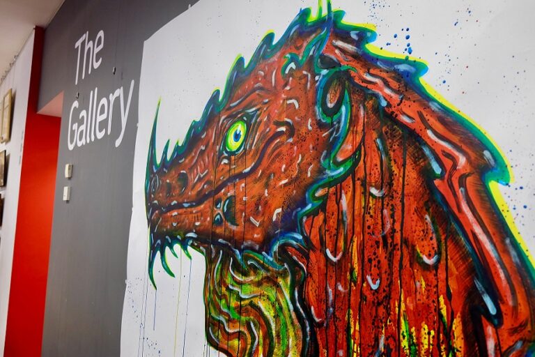 The Gallery wall, featuring a large, red dragon painted on paper